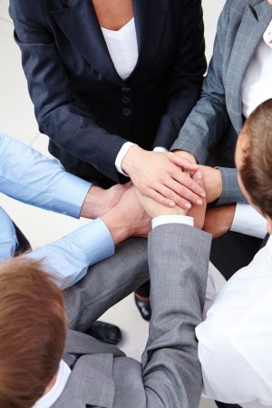 Image of business people hands on top of each other